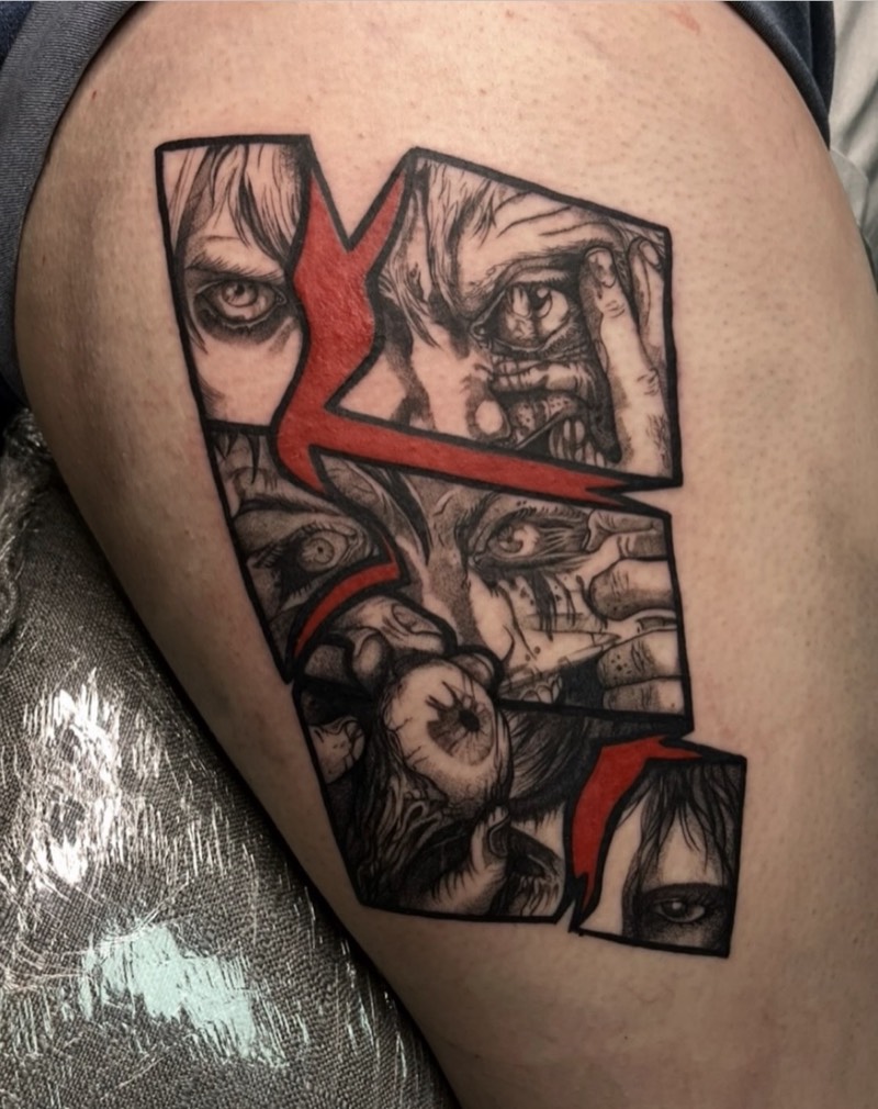 Completed tattoo on the thigh: jagged panels of staring eyes and faces in black and grey, split by a red lightning shape